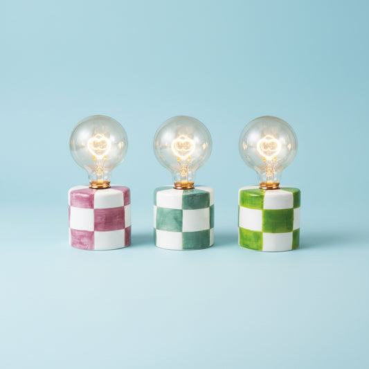 Three checkered lamp bases with light bulbs on a white background