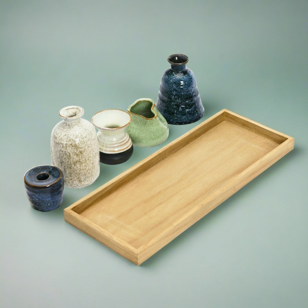 Mango wood tray with one taper candle holder and four glass bud vases styled as a rustic home centerpiece.