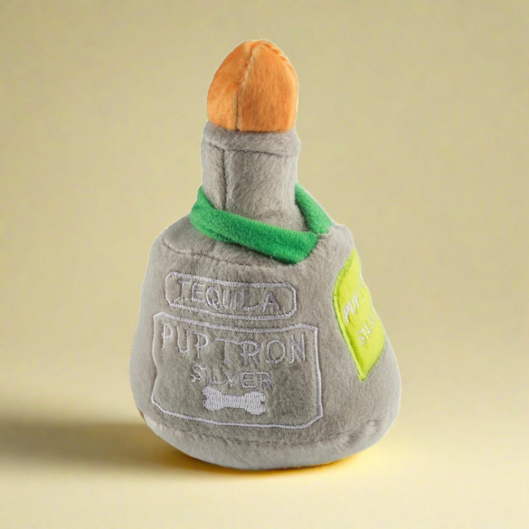 Plush dog toy shaped like a tequila bottle, featuring a soft exterior and hidden squeaker, perfect for playful pups who enjoy a spirited twist during playtime.