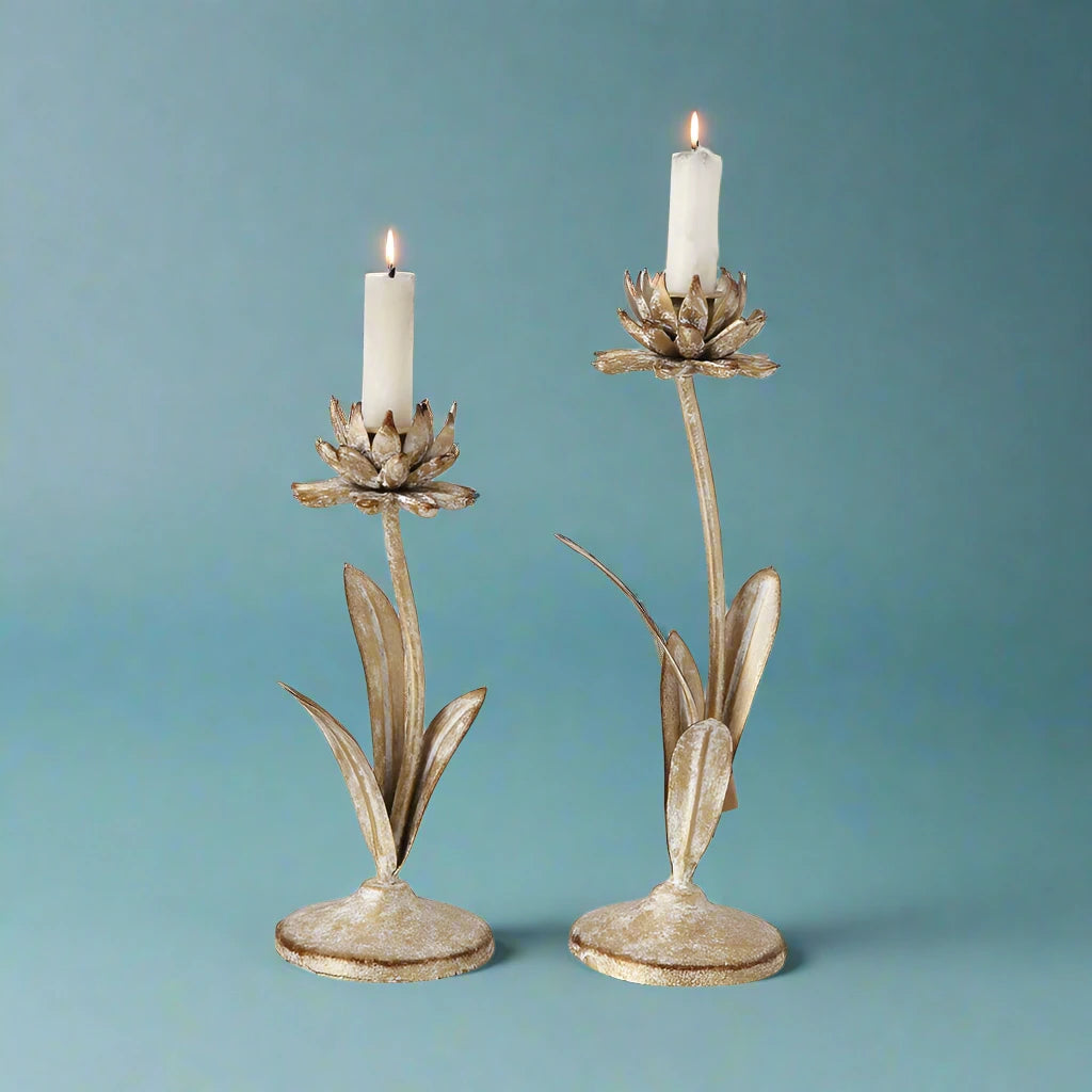 Set of two distressed white and gold flower-shaped metal candle holders for taper candles