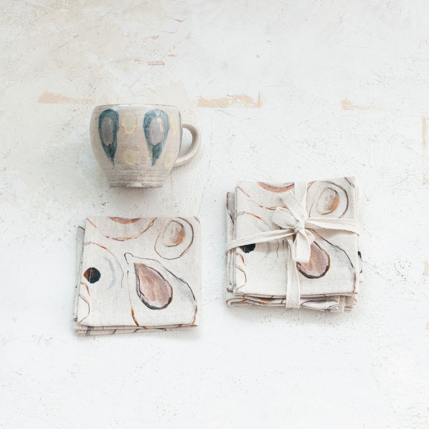 Set of four 10-inch square cotton and linen cocktail napkins with oyster pattern.