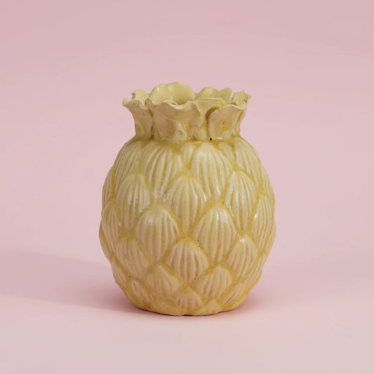 Yellow pineapple-shaped vase on a pink background