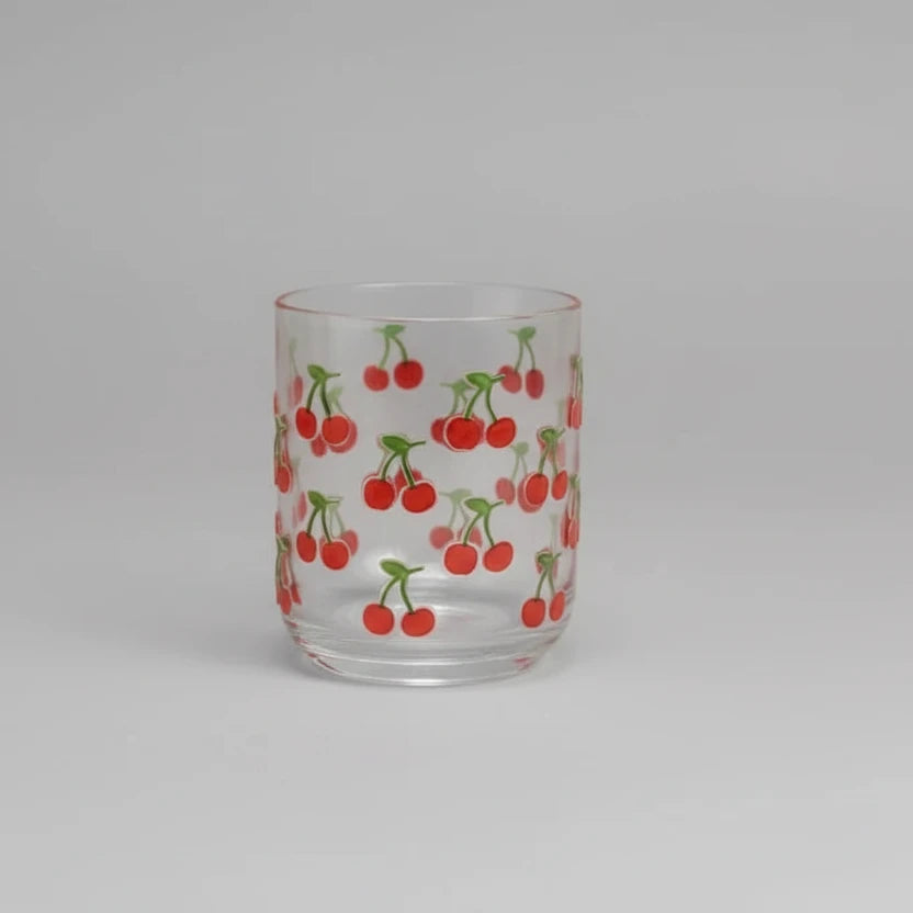 Clear glass tumbler with cherry pattern on a white background