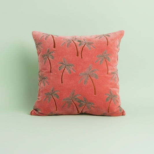 Coral pillow with palm tree pattern on a white background