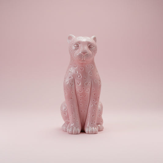 Pink ceramic panther figurine on a white background