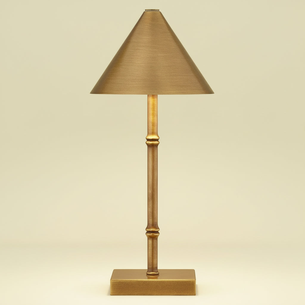 Gold table lamp with a conical shade on a white background