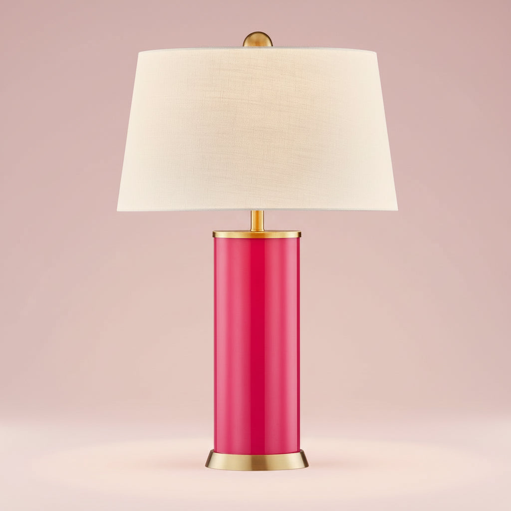 Table lamp with a pink base, gold accents, and a white shade on a white background