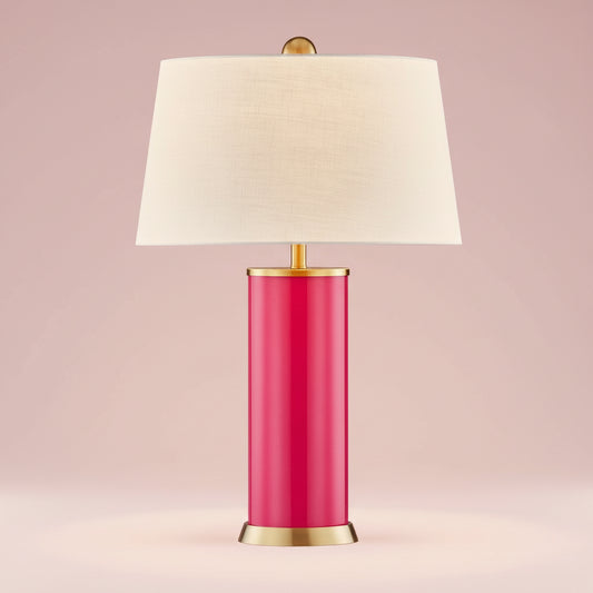 Table lamp with a pink base, gold accents, and a white shade on a white background