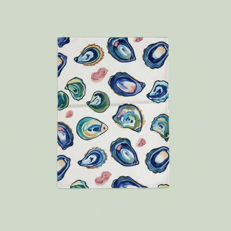 Colorful oyster pattern on a white towel with green onions on a dark surface