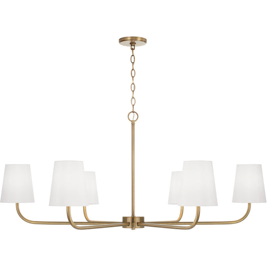 Aged brass chandelier with six white fabric shades, styled with modern curves and timeless warmth.