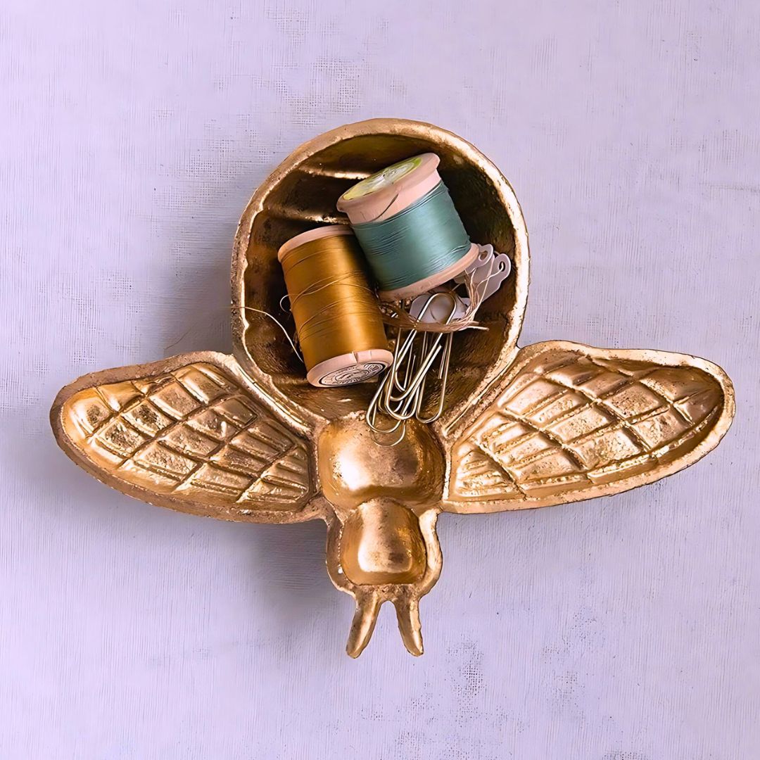 A golden bee-shaped dish, ideal for holding jewelry, soaps, or trinkets, adding a whimsical touch to a bathroom or kitchen counter.