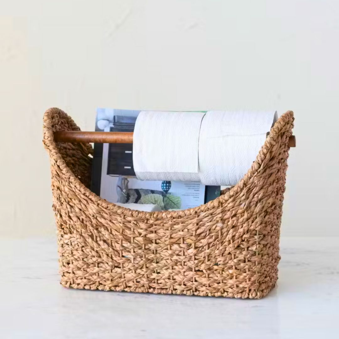 An oval-shaped rattan woven basket with handles, ideal for storage or decor, adding a rustic, natural touch to any room.