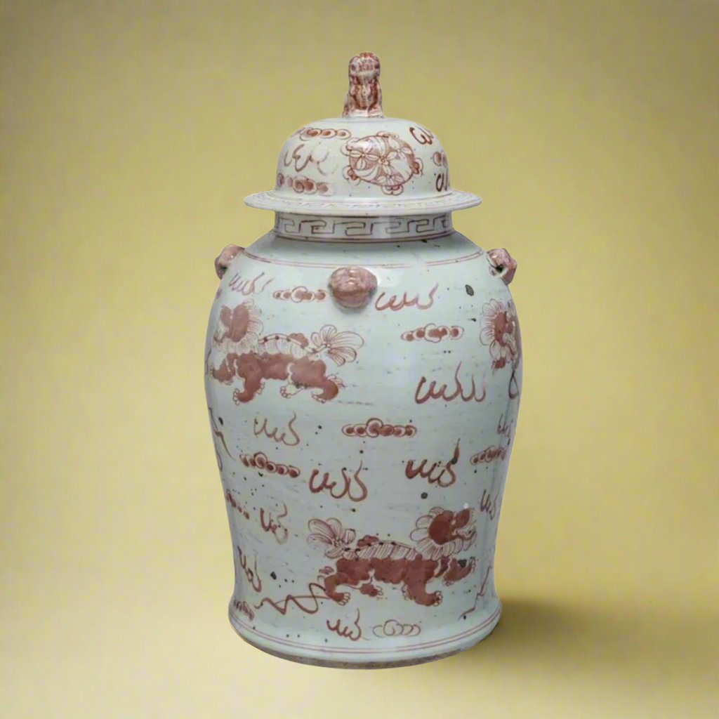 A vintage ginger jar with a classic design, featuring intricate details, displayed as a decorative piece on a mantel.