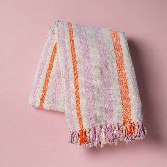 Peach-colored_throw_blanket_made_from_sustainable_recycled_materials_perfect_for_adding_warmth_and_an_eco-friendly_touch_to_any_room.
