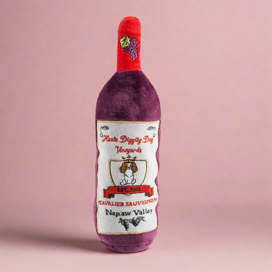 Plush_dog_toy_shaped_like_a_wine_bottle_featuring_a_soft_exterior_and_hidden_squeaker_ideal_for_playful_pups_who_enjoy_a_unique_and_entertaining_play_experience.