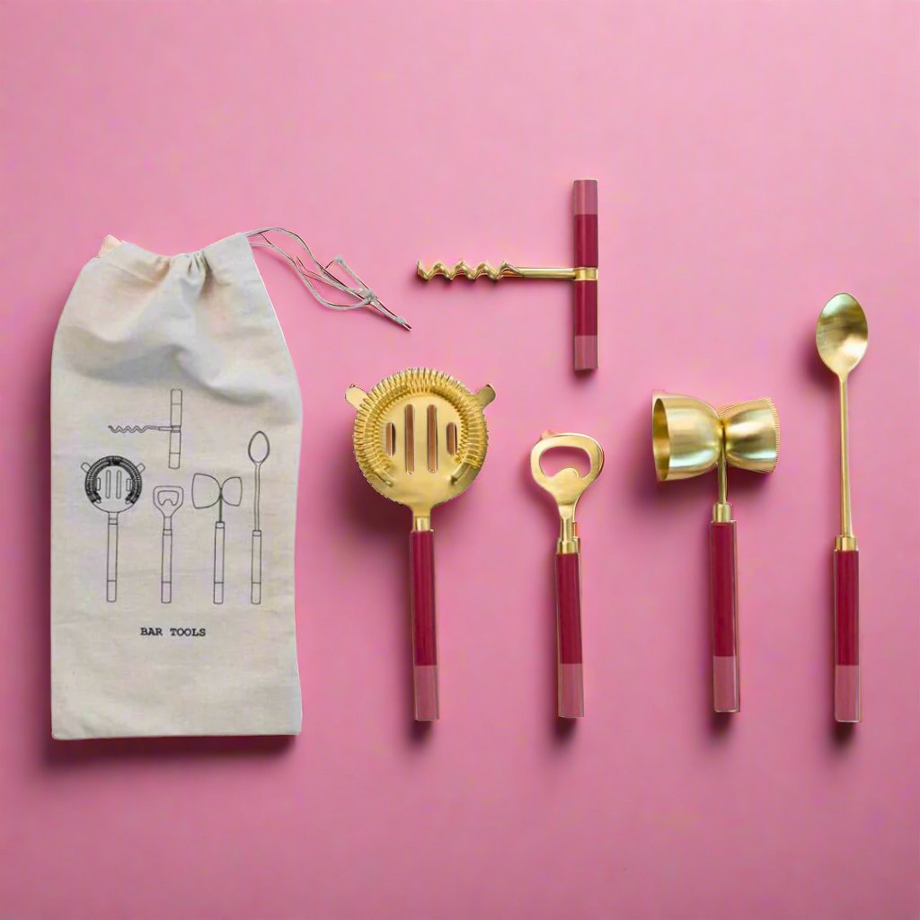 Set_of_five_pink_bar_tools_with_pink_resin_handles_and_a_vintage_brass_finish_including_a_stirring_spoon_strainer_jigger_corkscrew_and_bottle_opener_perfect_for_any_home_bar_setup.