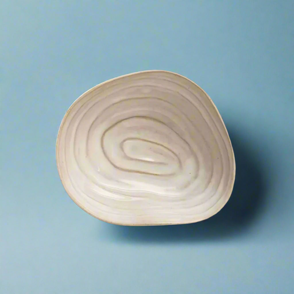 Stoneware_bowl_with_a_shell-inspired_design_perfect_for_serving_snacks_or_as_a_decorative_piece_adding_a_unique_coastal_charm_to_any_table_setting.