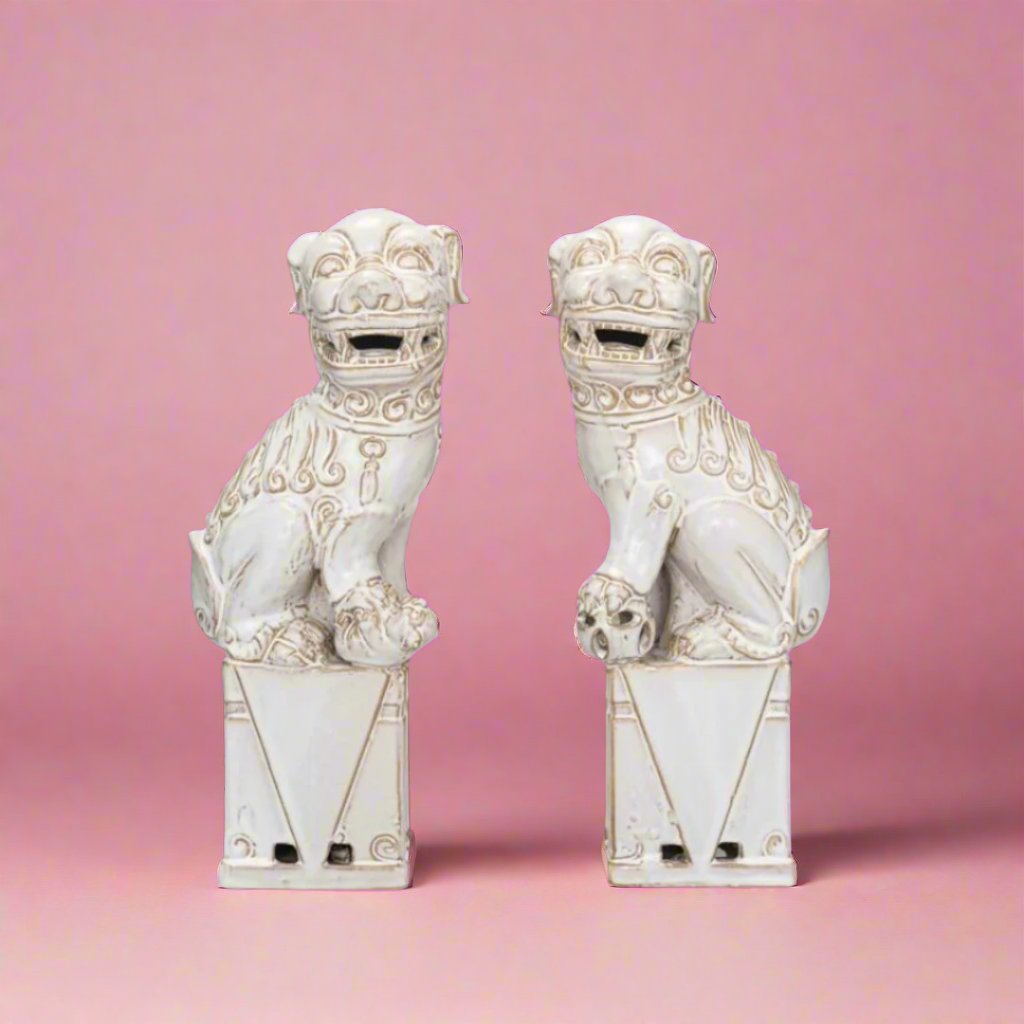 White dog-shaped bookends with intricate details, designed in an elegant, exotic style, placed on a wooden shelf.