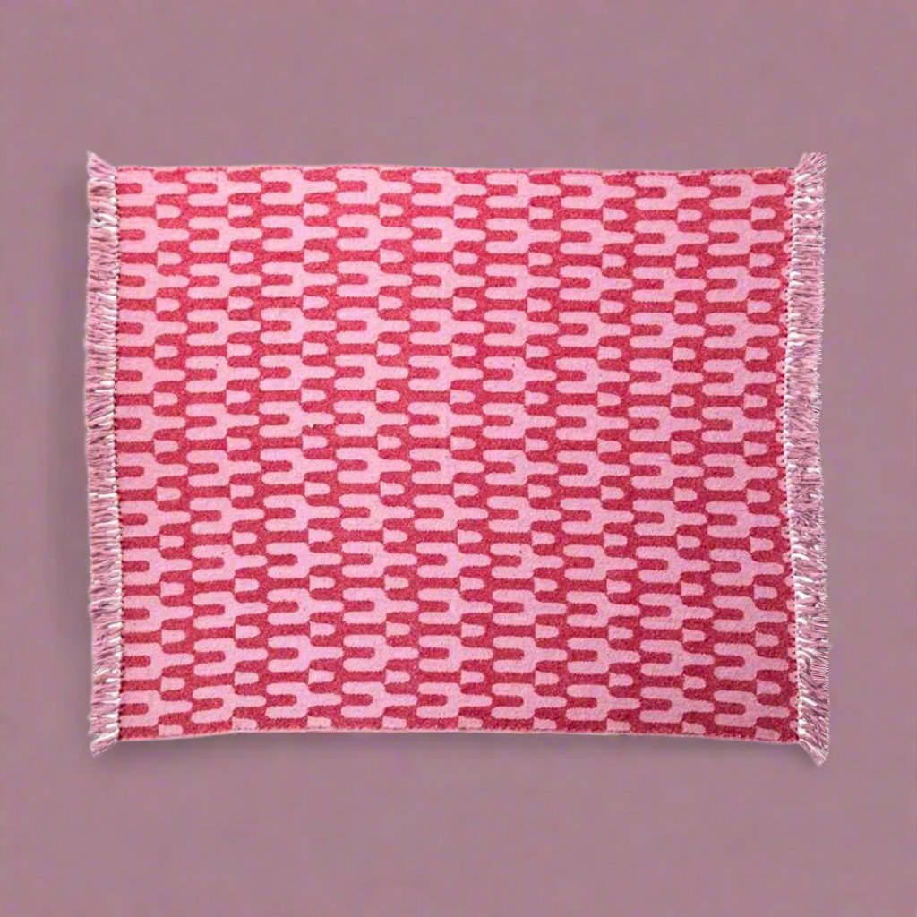 Woventhrowblanketmadefromarecycledcottonblend_featuringastylishpinkpattern_idealforaddingwarmthandsustainablestyletoalivingroomorbedroom.copy