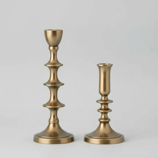 Two gold candle holders on a white background