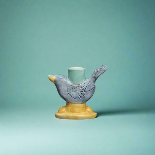 Hand-painted stoneware bird-shaped taper candle holder with navy, teal, and yellow reactive glaze.