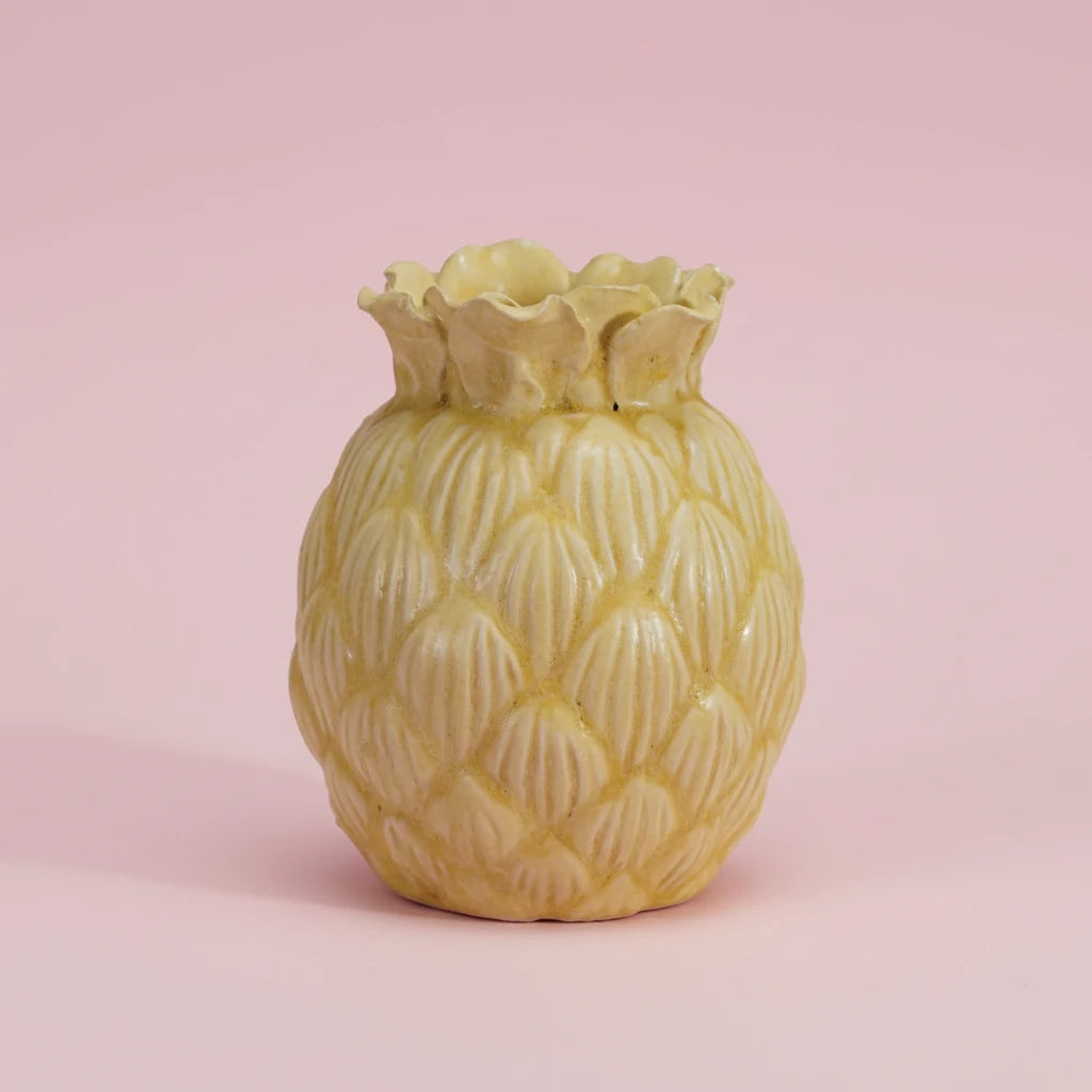 Yellow pineapple-shaped vase on a pink background
