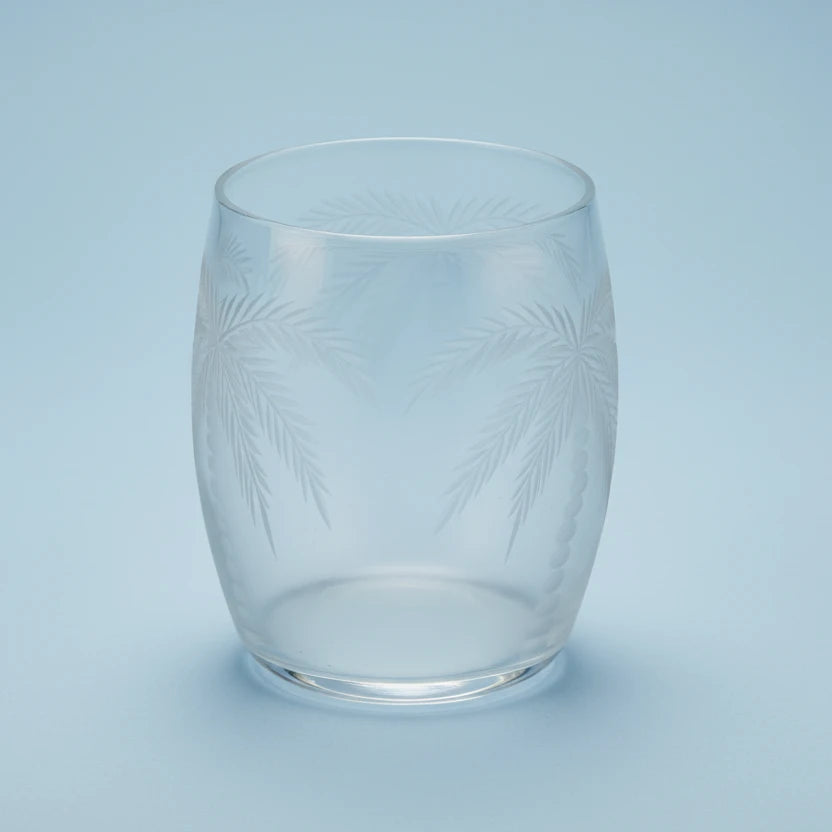 Clear glass tumbler with leaf pattern on a white background