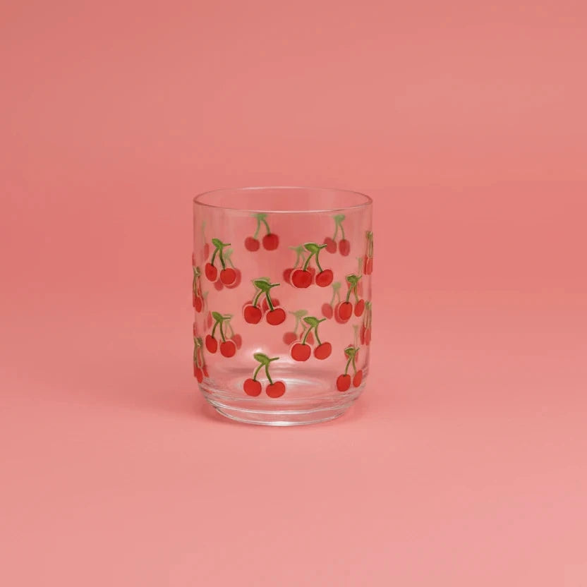 Clear glass tumbler with cherry pattern on a white background