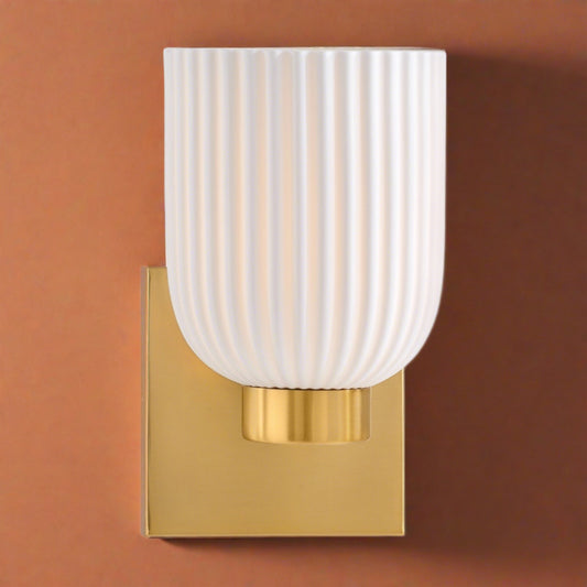 Isla Blanca One Light Wall Sconce by Savoy House in Warm Brass Finish (9-3172-1-322)Introducing our Isla Blanca Porcelain Glow Sconce, a masterpiece of design envisioned by a renowned interior designer and TV host. Inspired by the belief that luxury lies in the details, this exquisite sconce is a celebration of elegance and sophistication.
