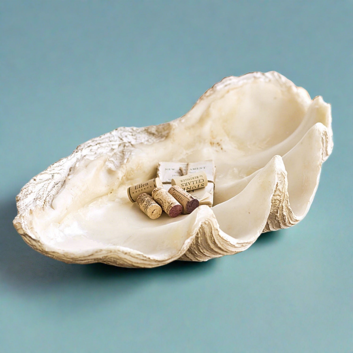 Imperial Objet by Regina Andrew in White Finish (20-1123)Introducing our Coastal Clam Shell Bowl, a stunning decorative piece that brings the tranquility of the shoreline to your living space. This large clam replica serves not only as a bowl but also as a striking objet d'art, adding a touch of coastal elegance to any room.